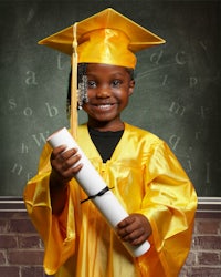 a little girl in a graduation gown holding a diploma